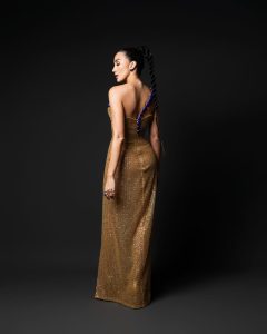 Un vestido columna en tonos oro y bronce, inspirado en el antiguo Egipto, cobra vida con un imponente escorpión-joya que recorre la silueta como símbolo de poder