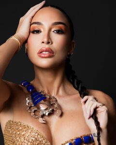 Un vestido columna en tonos oro y bronce, inspirado en el antiguo Egipto, cobra vida con un imponente escorpión-joya que recorre la silueta como símbolo de poder